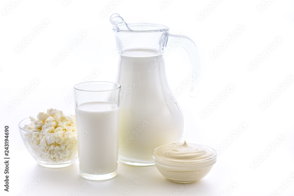 Useful dairy kitchen for bone health. Milk in a jug and a cup on a white background. Fresh sour cream and cottage cheese. Useful dairy kitchen for bone health. Milk in a jug and a cup on a white background. Fresh sour cream and cottage cheese.