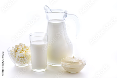 Useful dairy kitchen for bone health. Milk in a jug and a cup on a white background. Fresh sour cream and cottage cheese.
