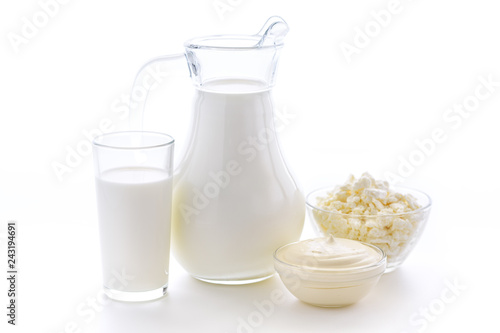 Fresh cow milk in a glass on a white background with a useful curd and sour cream on a white background. Delicious dairy products.