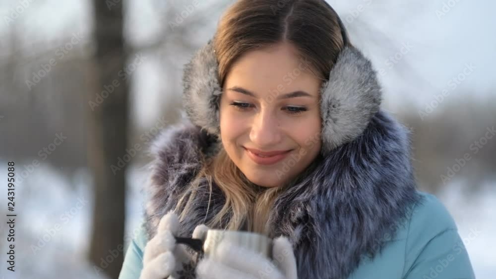 young beautiful woman drinks hot tea in winter in the park young beautiful woman drinks hot tea in winter in the park