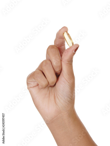 The hand of a woman holding a vitamin pill