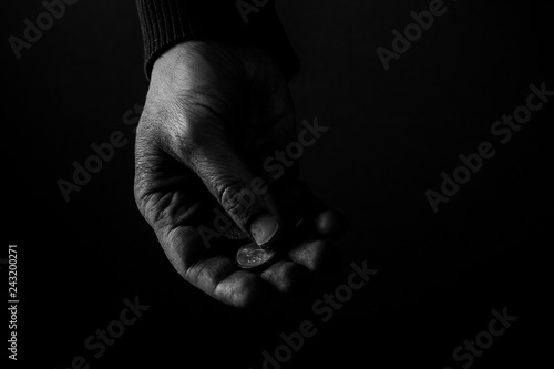 Poor Man holding coins  Helping hands concept of compassion  dramatic light