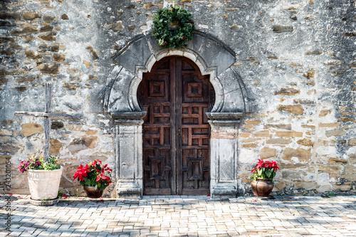 Entrance door to Mission Espada in San Antonio Texas on a bright sunny day with christmas decorations - Wooden rustic door