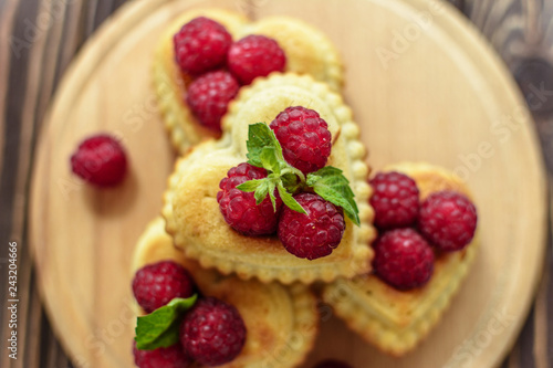 Delicious heart-shaped muffins with raspberries and mint. Cupcakes for Valentine's Day