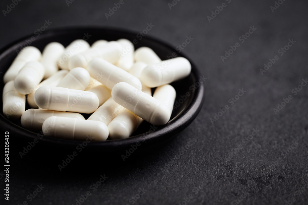 Glutamine ( amino acid ). Nutrition for bodybuilding. Fitness supplements on black stone background. Close up. Copy space. Glutamine ( amino acid ). Nutrition for bodybuilding. Fitness supplements on black stone background. Close up. Copy space.