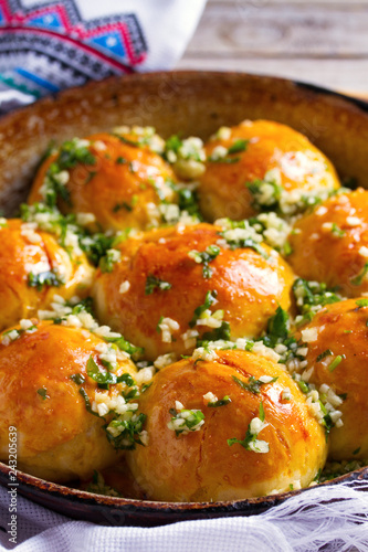 Buns Pampushky - Ukrainian garlic bread. Bread rolls with garlic and parsley in baking dish