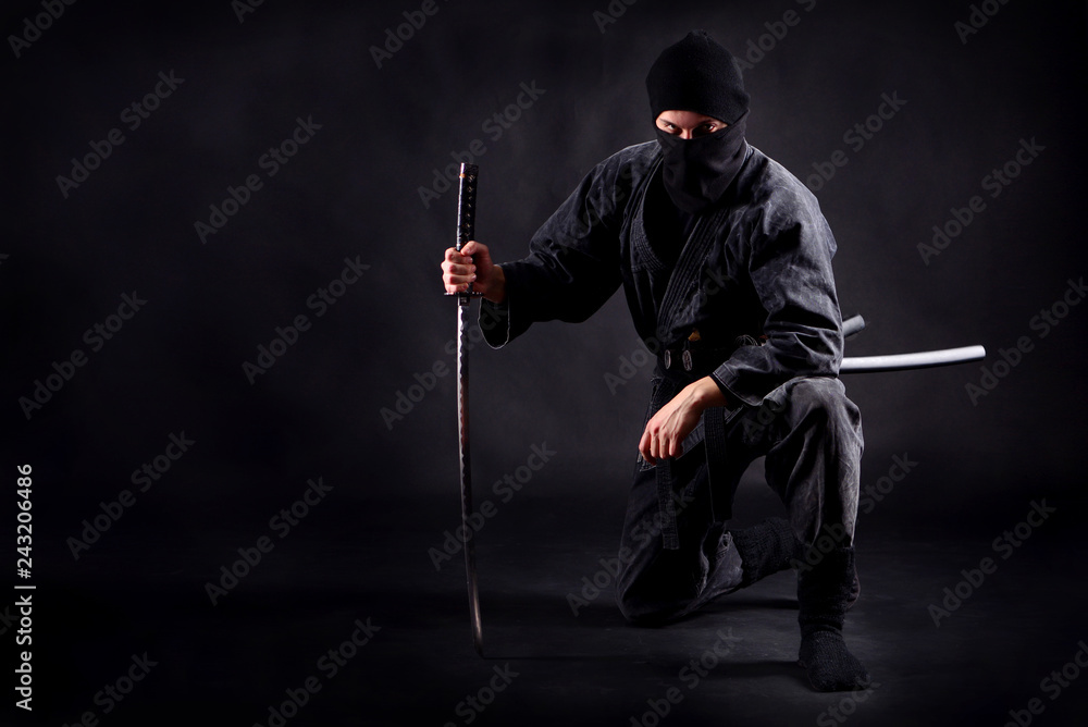 Ninja samurai crouched on one leg and propped on a sword Stock Photo |  Adobe Stock