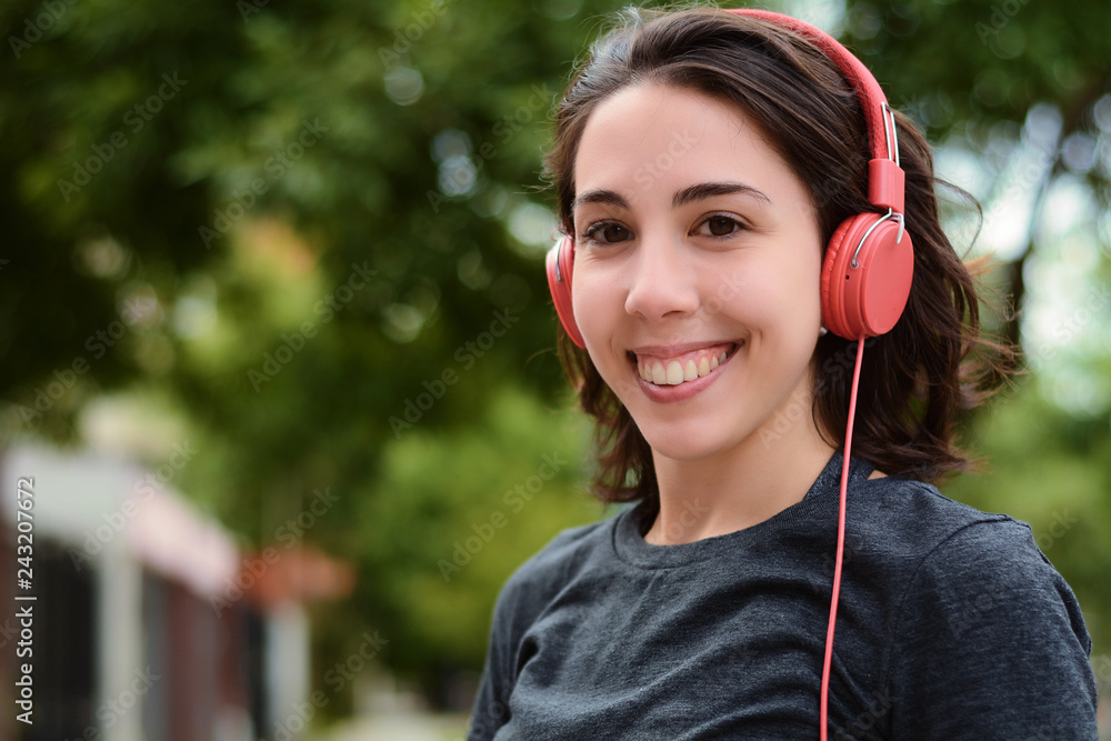 Portrait of young beautiful woman with red headphones listening music Portrait of young beautiful woman with red headphones listening music