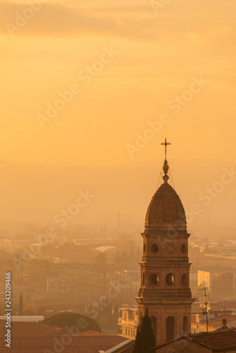 Abbey of Saints Flora e Lucilla beautiful and characteristic old bell tower, erected in 1650 in Arezzo old town, wrapped in sunset mist magic atmophere (with copy space) photo