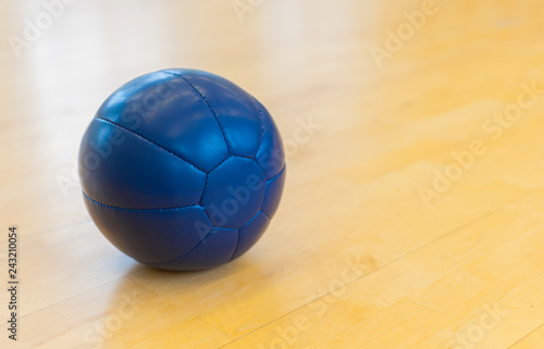 Blue medicine weight ball on wooden floor. Crossfit ball