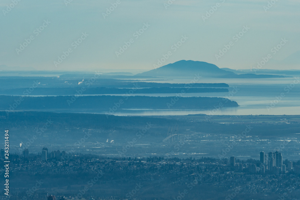 view of  Vancouver by the Fraser river  covered in mist from the mountain top