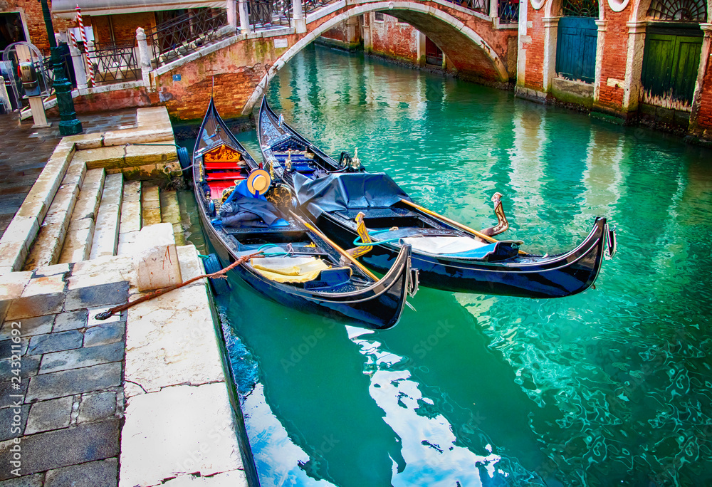 Two gondolas on water of canal in Venice, Italy.