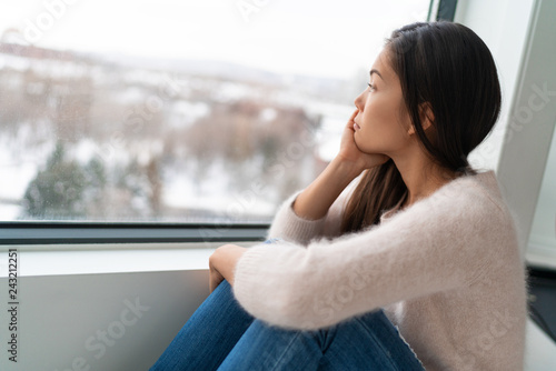 Winter seasonal affective disored SAD depression mood alone Asian girl feeling lonely - stress, anxiety, melancholy emotions. Sadness at home. photo