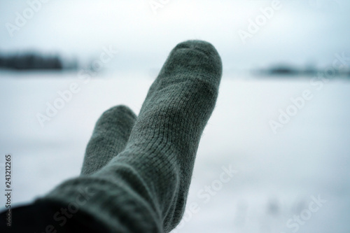 View of warm socks on legs on snowy background.