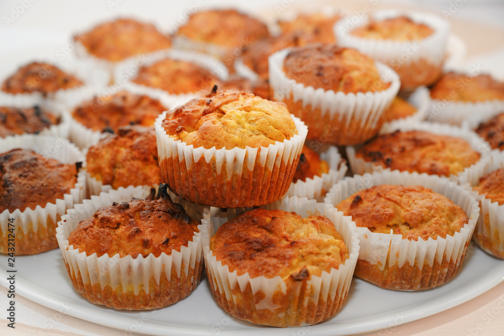 homemade carrot muffins in paper sleeves served on a white tray homemade carrot muffins in paper sleeves served on a white tray