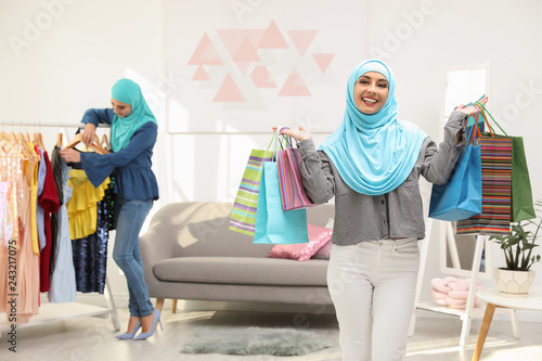 Muslim woman with shopping bags in modern shop