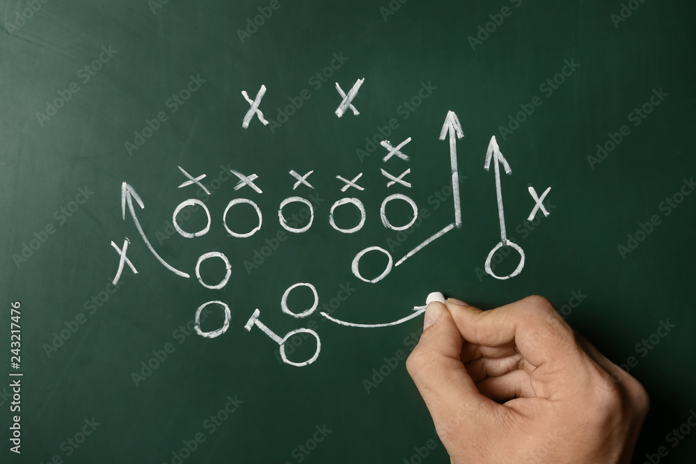 Fototapeta premium Man drawing football game scheme on chalkboard, top view