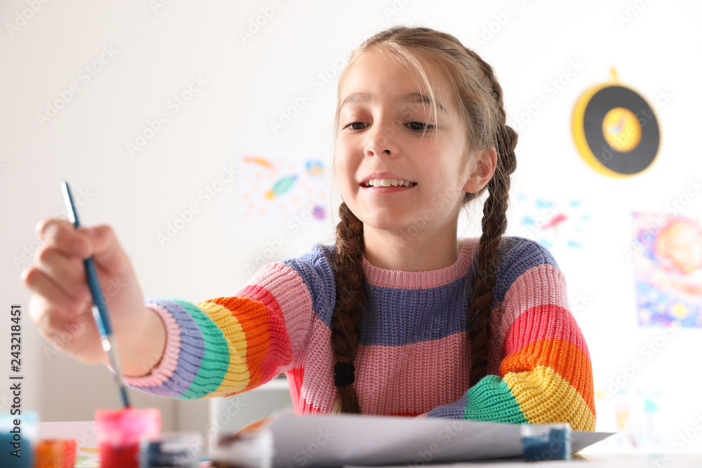 Fototapeta premium Little girl painting picture at table indoors