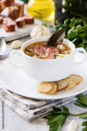 Thick pea soup with smoked meats in a white plate