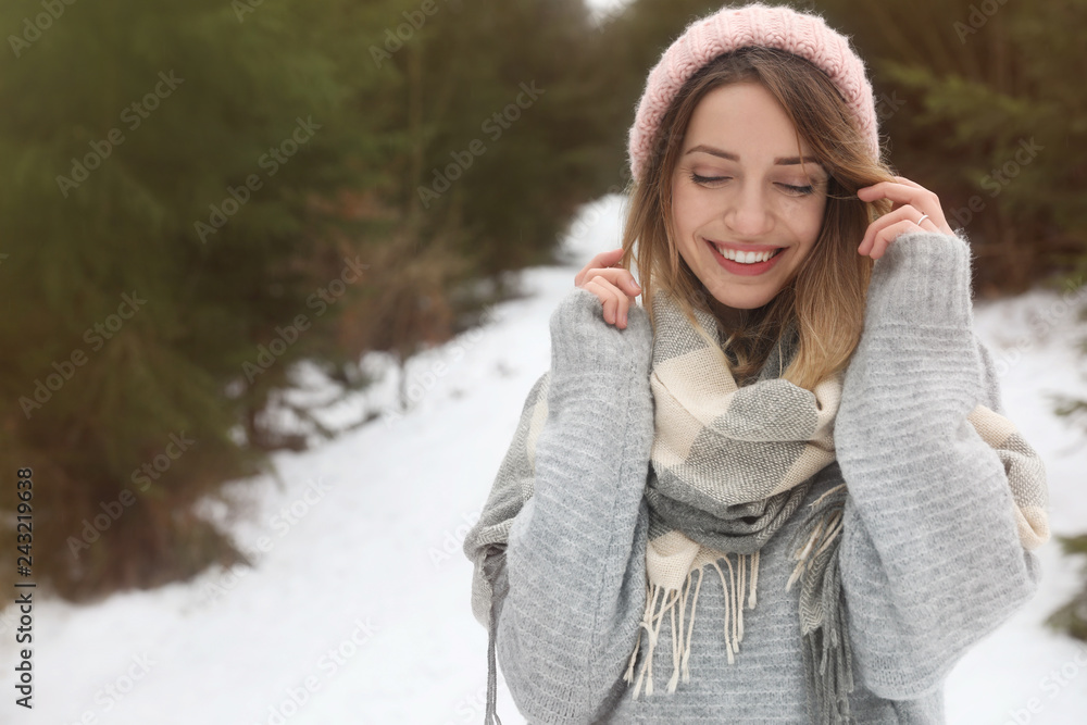 Young woman in snowy conifer forest, space for text. Winter vacation Young woman in snowy conifer forest, space for text. Winter vacation