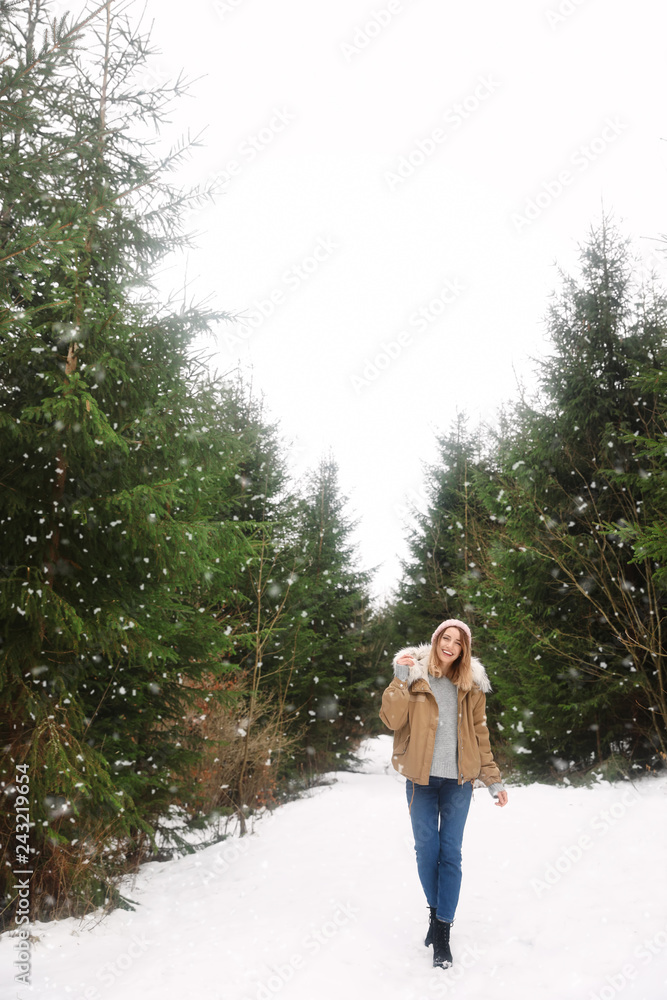 Young woman in snowy conifer forest. Winter vacation Young woman in snowy conifer forest. Winter vacation