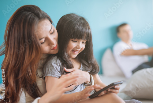 Portrait Happy Daughter playing smartphone with her mother