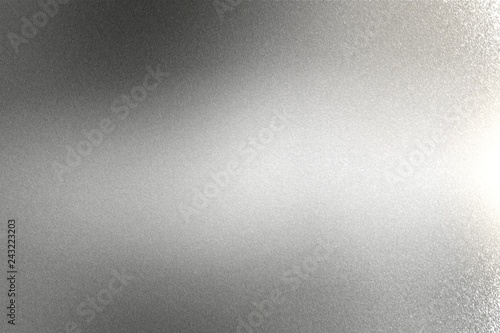 Light shining on brushed silver metal wall texture, abstract background