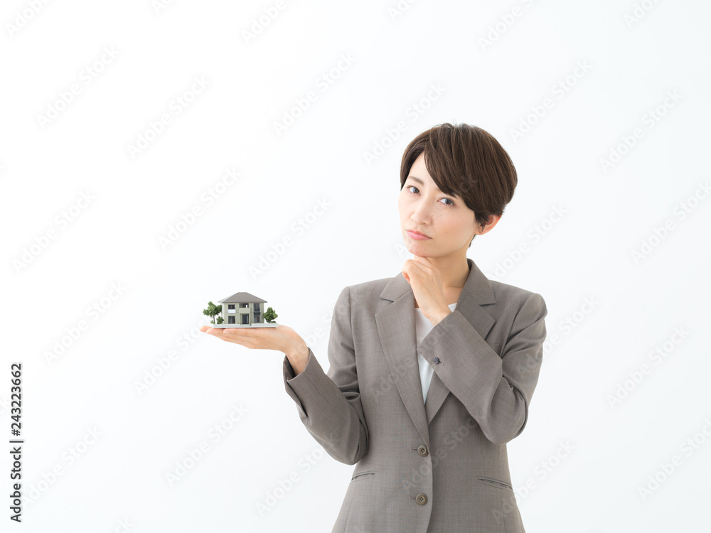 悩む・住宅模型を持つ女性 悩む・住宅模型を持つ女性