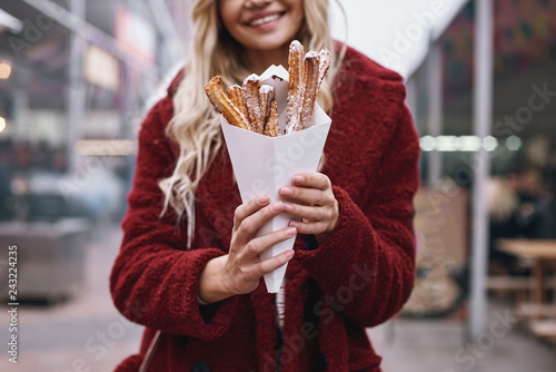 Close-up of young blonde woman eatting churros photo