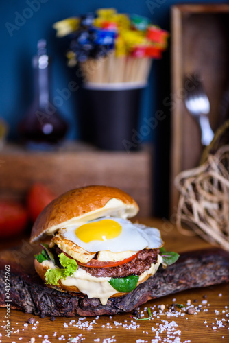 Burger with beef, egg and cheese. French fries