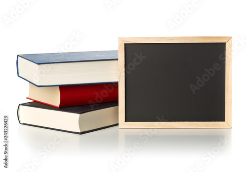 Empty, blank, black chalkboard with stack of books over white