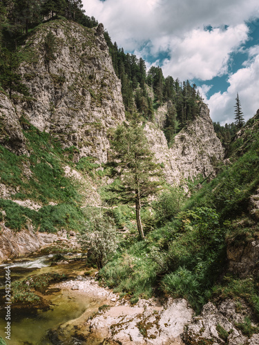 View of river passing through mountain against cloudy sky