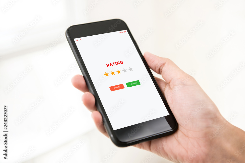 Mobile phone user giving feedback of the application by rating with stars Mobile phone user giving feedback of the application by rating with stars