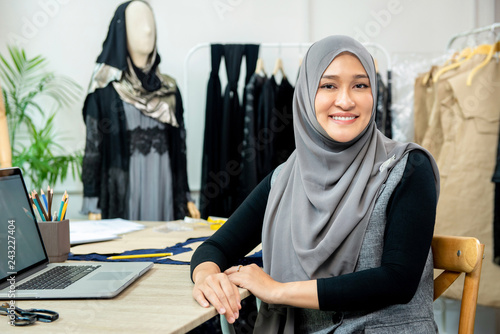 Asian muslim woman designer in her tailor shop photo