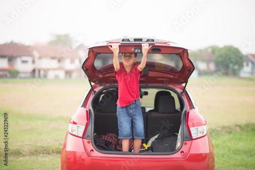 Little boy closing the back door car