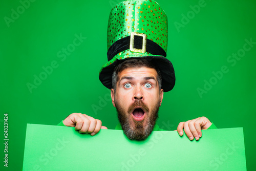 Green patricks background. Man in Saint Patrick's Day leprechaun party hat having fun on green background. Copy space. photo