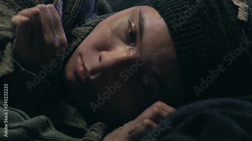 Homeless teen boy crying, missing home, orphan or child abandoned by state