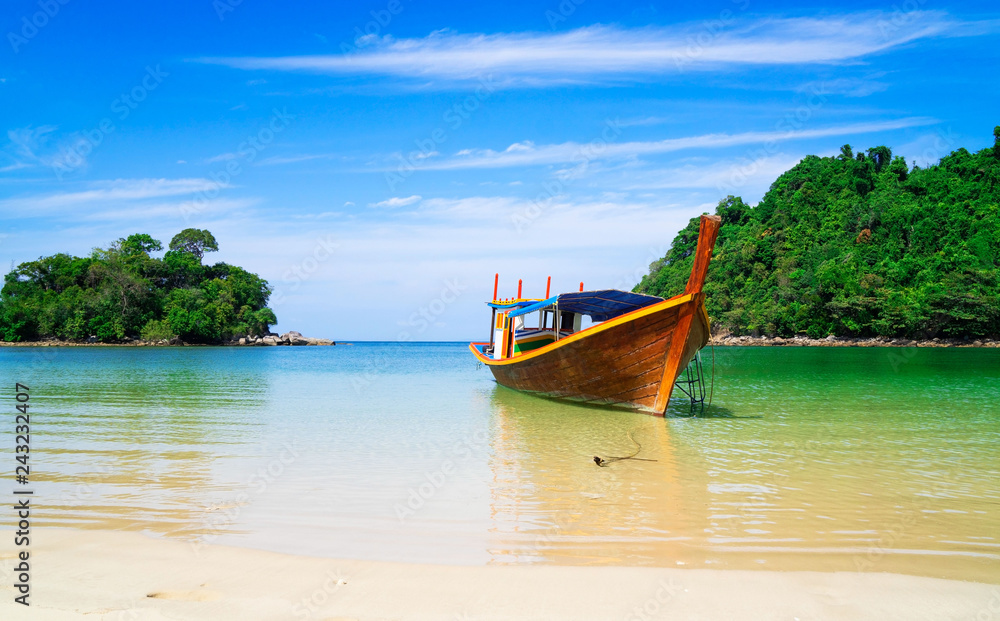 Obraz premium piękna sceneria z drewnianą łodzią na plaży biały piasek w błękitne morze i błękitne niebo na tropikalnej plaży.