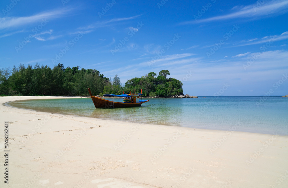 Naklejka premium piękna sceneria z drewnianą łodzią na plaży biały piasek w błękitne morze i błękitne niebo na tropikalnej plaży.