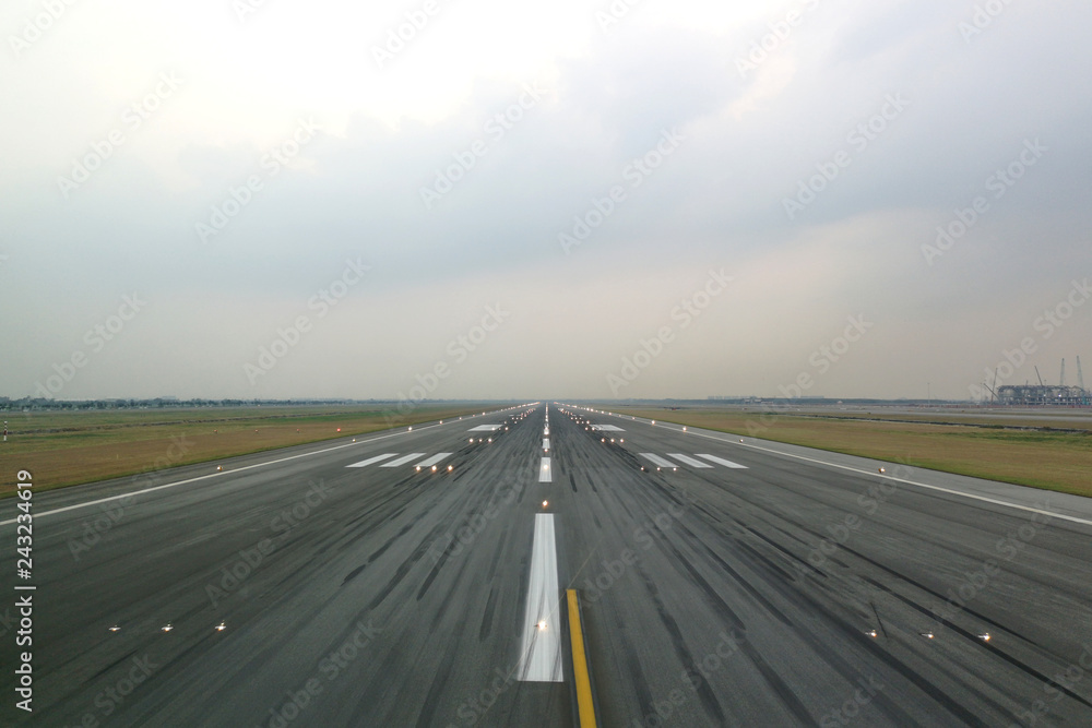 Airport runway in the evening with light system opened, ready for airplane landing or taking off. Seen from the airplane cockpit. Modern aviation concept.