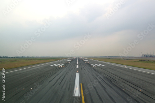 Airport runway in the evening with light system opened, ready for airplane landing or taking off. Seen from the airplane cockpit. Modern aviation concept. © Kawee