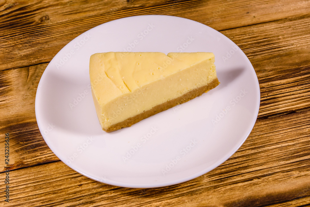 White plate with cheesecake New York on wooden table