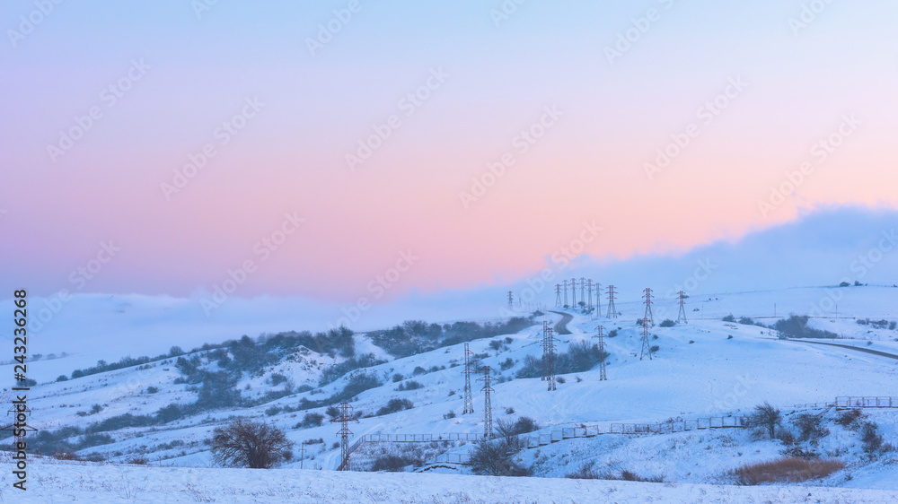Power poles in a snowy field, winter landscape Power poles in a snowy field, winter landscape