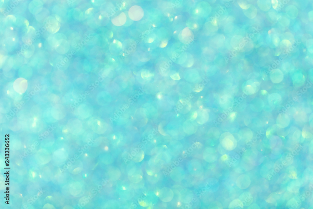 Blurred shiny turquoise background with sparkling lights.