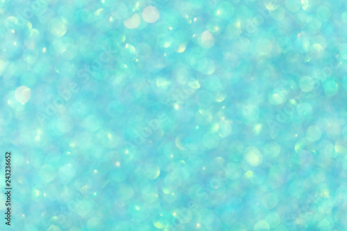 Blurred shiny turquoise background with sparkling lights.
