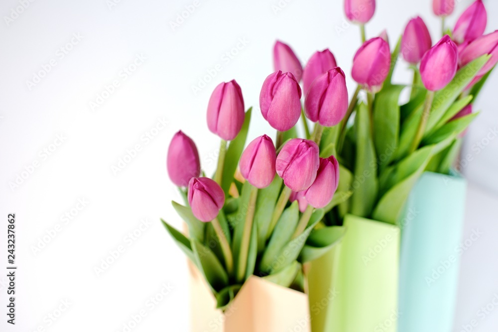 Obraz premium Fresh bright bouquet of pink tulip in paper bags. Beautiful greeting card. Spring holidas concept.