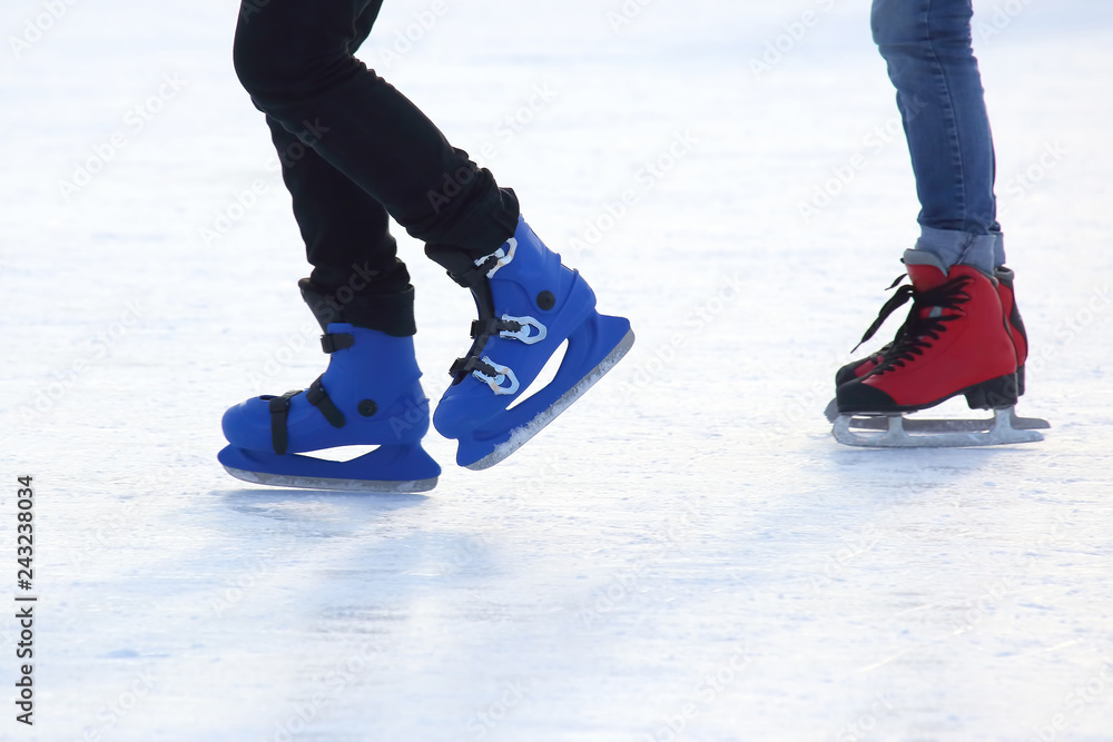 feet of different people skating on the ice rink feet of different people skating on the ice rink