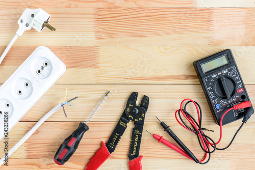 Electrical equipment and tools on wooden table with copy space.