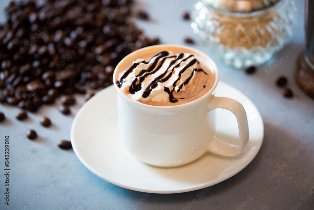 cup of coffee with whipped cream and beans