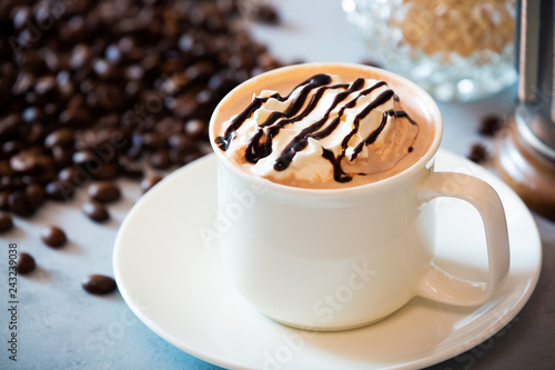 cup of coffee with whipped cream and beans